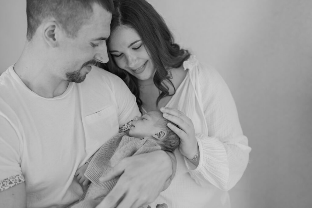 Eltern halten ihr neugeborenes Baby im Arm bei einem Babyshooting in Marktheidenfeld