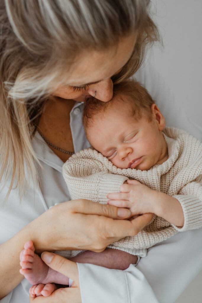 Porträt von einer Mutter mit ihrem neugeborenen Baby im Arm im Tageslichtatelier in Kreuzwertheim