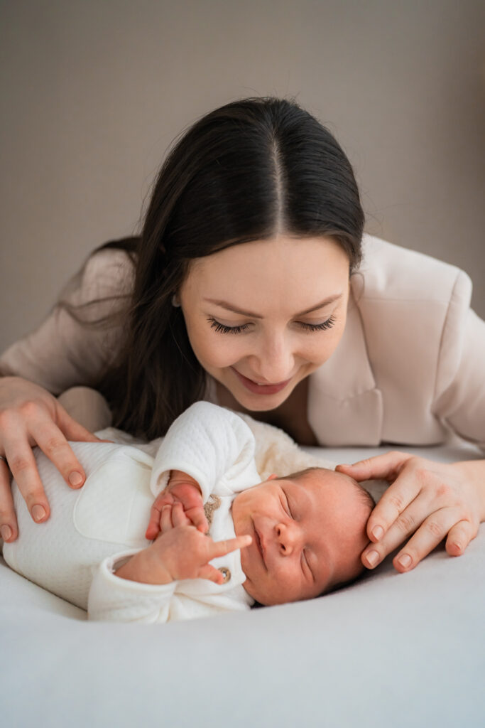 Eine Mutter küsst ihr Neugeborenes bei einem Babyshooting in Wertheim