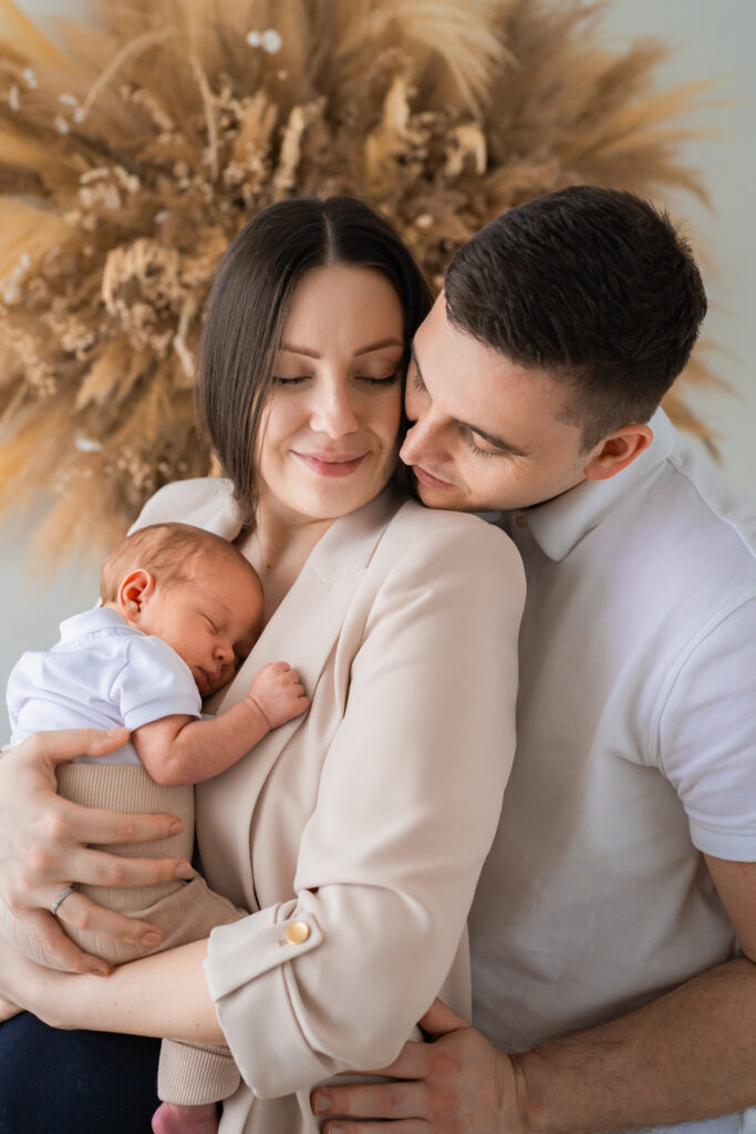 Eltern halten ihr neugeborenes Baby bei einem natürlichen Familienshooting im Atelier in Kreuzwertheim.