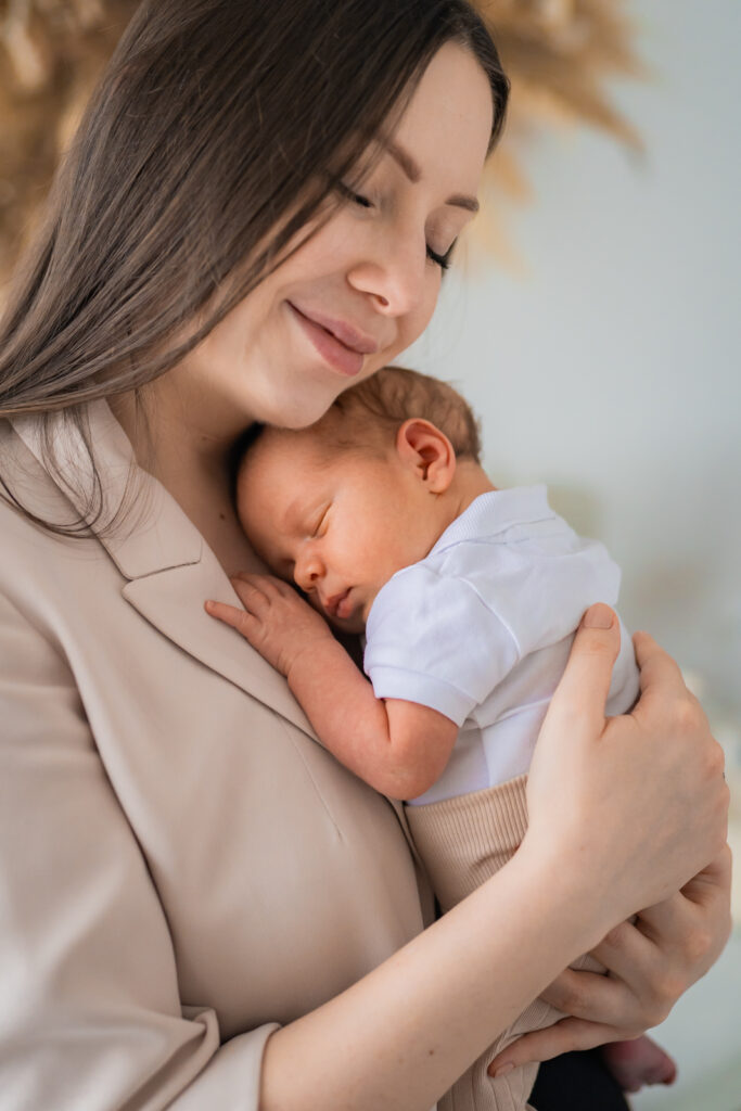 Mutter hält ihr Baby im Arm bei einem natürlichen Neugeborenenshooting im Tageslichtatelier in Kreuzwertheim