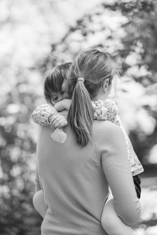 Mutter hält Kind auf dem Arm bei einem Familienshooting im Freien