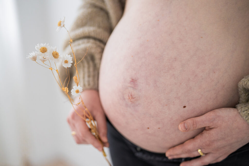 Trockenblume am Babybauch